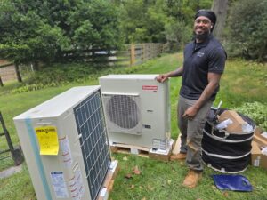 HVAC technician installing a Goodman heat pump system outdoors